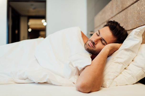 selective focus of handsome bearded man sleeping in bed  - Foto, Imagen
