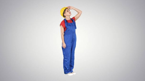 Engineer construction worker woman looking up at a building or statistics or graph laughing in the end on gradient background. - Foto, Imagen