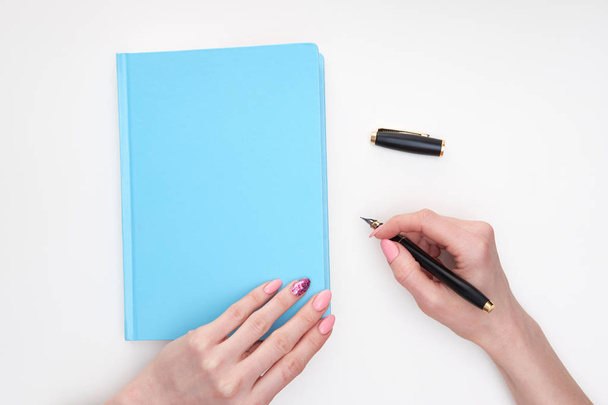 Frauenhände schreiben Notizen im Tagebuch, weißer Hintergrund - Foto, Bild
