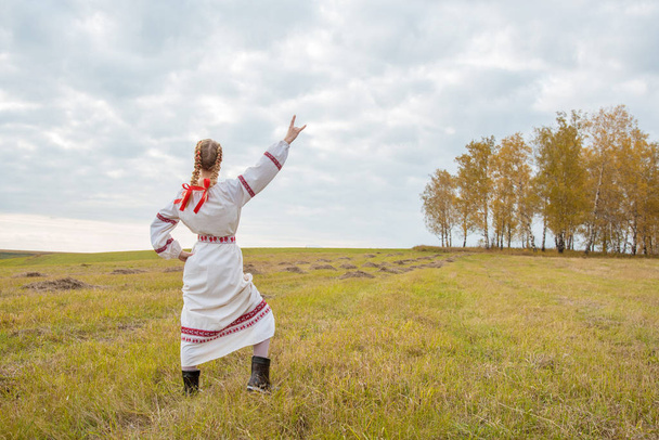 Dívka ve slovanských šatech s červenou stuhou ve vlasech - Fotografie, Obrázek