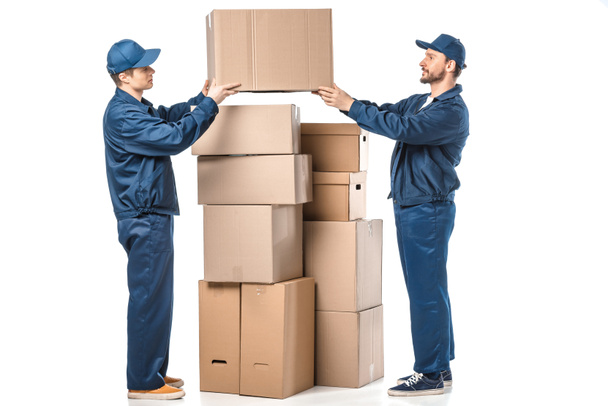 twee verhuizers in uniform Holding kartonnen doos op wit  - Foto, afbeelding