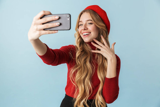 Photo of charming girl 20s wearing red beret taking selfie on mo - Photo, Image