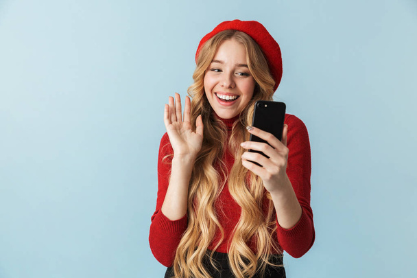 Photo of gorgeous girl 20s wearing red beret using mobile phone - Фото, изображение