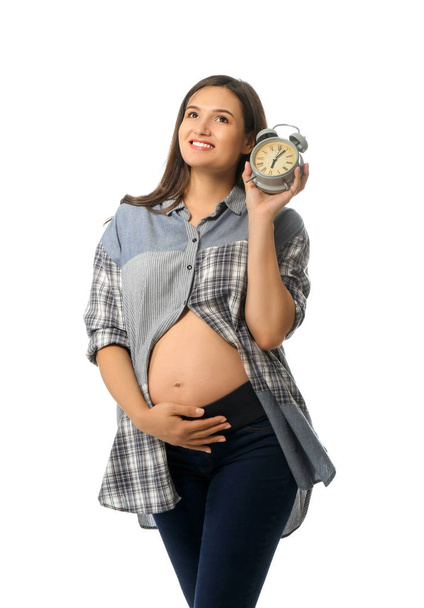 Krásná těhotná žena s hodinami na bílém pozadí - Fotografie, Obrázek
