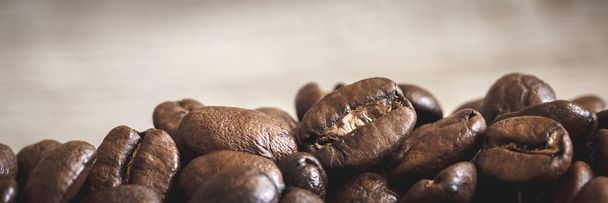 Close-up of coffee beans on wooden background - Valokuva, kuva