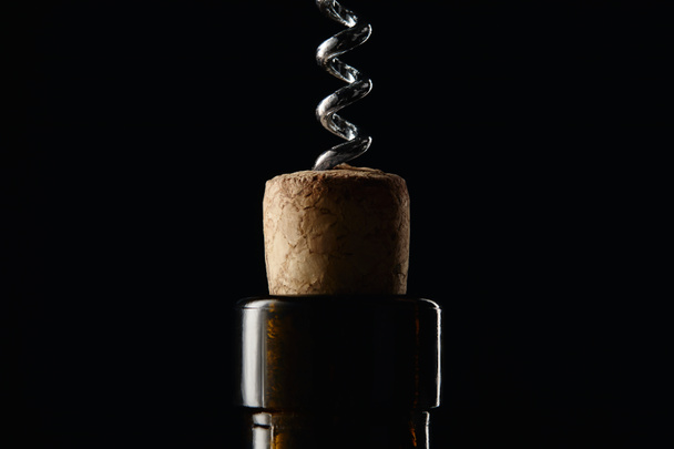 Vista de cerca de la botella con corcho de madera y sacacorchos aislados en negro
 - Foto, Imagen