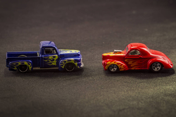 modèles réduits de chariots de jouets en métal sur fond noir. voitures colorées, différents modèles et barres chaudes
. - Photo, image