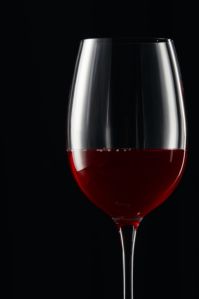 Glass with burgundy red wine isolated on black - Фото, изображение
