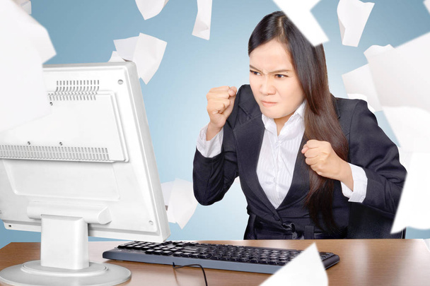 Molesto mujer de negocios asiática cuando se trabaja con papel volador scatte
 - Foto, Imagen