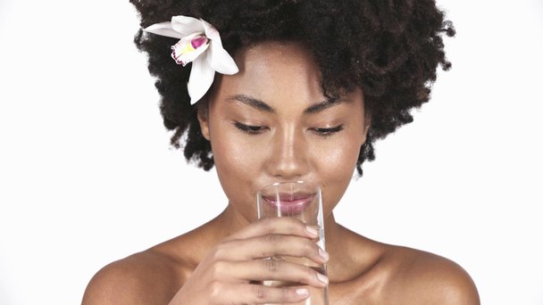 joyeuse fille américaine arfican souriant, regardant le verre et l'eau potable isolé sur blanc
  - Séquence, vidéo