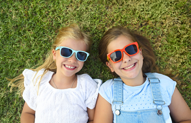 Bambini ridenti che indossano occhiali da sole per rilassarsi durante la giornata estiva
  - Foto, immagini
