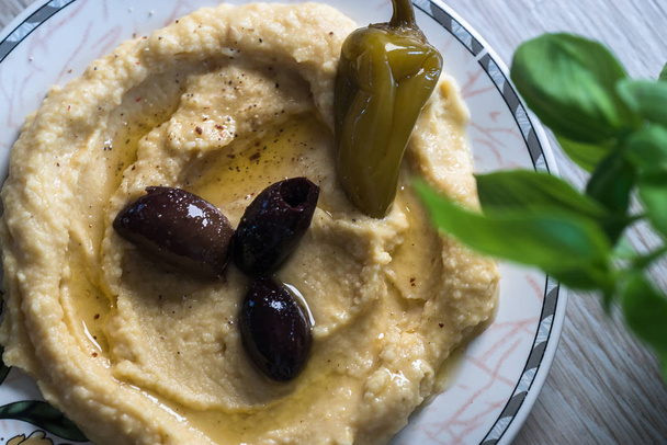 houmous aux olives et poivre sur assiette, trempette traditionnelle levantine
 - Photo, image