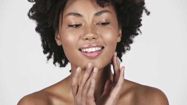 美しいブルネット アフリカ系アメリカ人女性カメラ目線と白で隔離の顔に触れる  - 映像、動画
