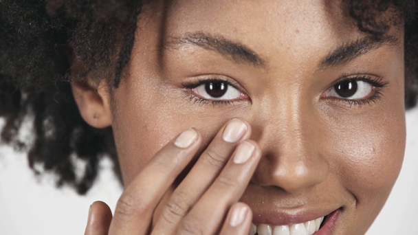 カメラ目線と白で隔離の顔に触れる美しいブルネットのアフリカ系アメリカ人少女のクローズ アップ  - 映像、動画