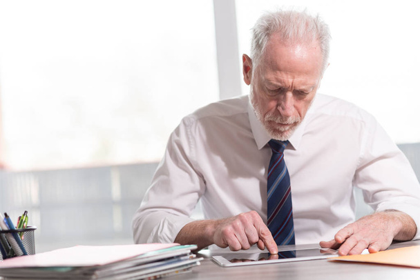 Portrait of senior businessman working on tablet - Φωτογραφία, εικόνα