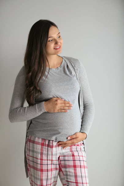 Kaunis raskaana oleva nainen harmaalla taustalla - Valokuva, kuva