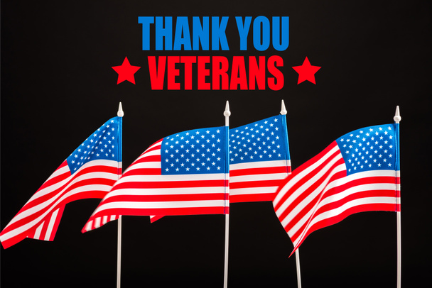 american flags with thank you veterans lettering isolated on black - Foto, Bild