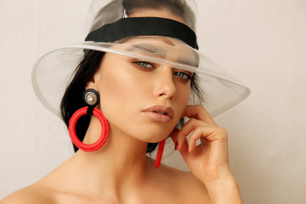 beautiful woman with dark hair in fashion transparent hat and lu - Zdjęcie, obraz