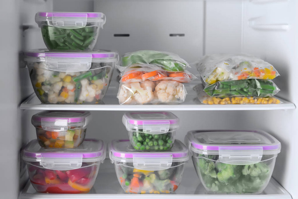 Δοχεία και πλαστικές σακούλες με κατεψυγμένα λαχανικά στο ψυγείο - Φωτογραφία, εικόνα