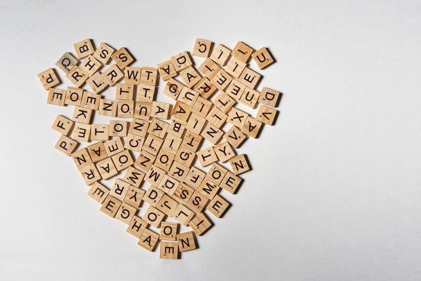 Alphabet letters on wooden square pieces forming heart shape - Foto, Imagen