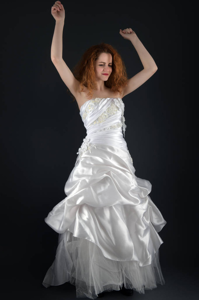 黒い背景の白いドレスを着た美しい若い女性 - 写真・画像