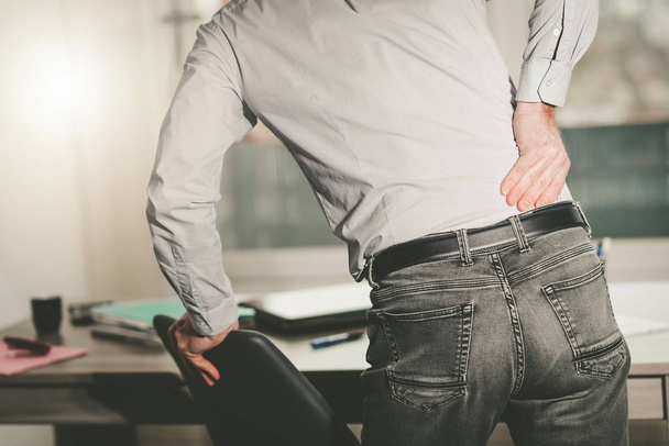 Businessman suffering from back pain, light effect - Фото, зображення