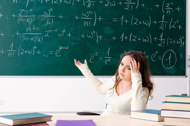 Jonge vrouwelijke wiskundeleraar voor schoolbord   - Foto, afbeelding