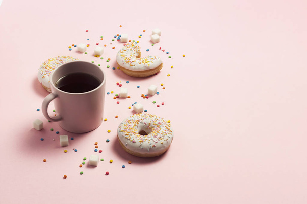 ピンクの背景のコーヒー、新鮮なおいしい甘いドーナツのカップ。ファーストフード、ベーカリー、朝食、お菓子のコンセプトです。ミニマリズム。コピー スペース フラット横たわっていた、トップ ビュー. - 写真・画像