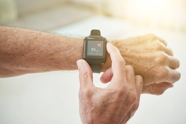 Crop shot of elderly man measuring pulse with modern smart watch in sunlight - Photo, Image