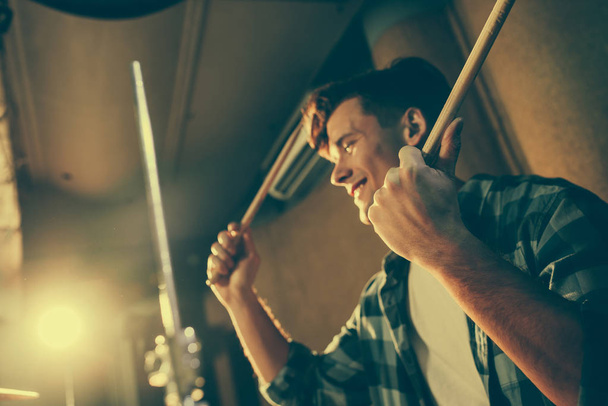 барабанные палочки в руках у веселого молодого барабанщика
 - Фото, изображение