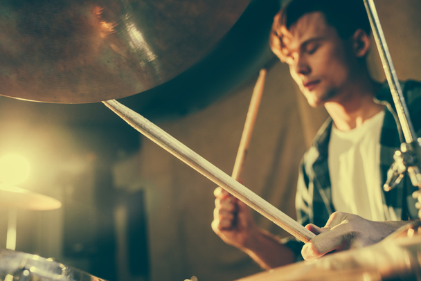 selective focus of drum sticks in hands of young drummer - Foto, imagen