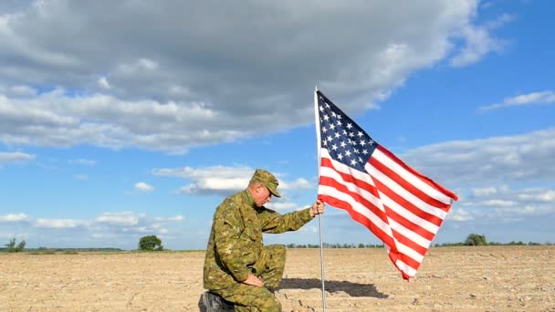 Voják na jednom koleni s americkou vlajkou zavěšený v Outdoorové scéně pomalý pohyb - Záběry, video