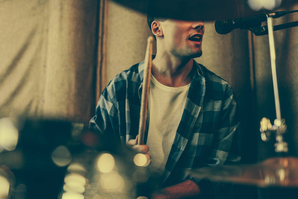 cropped view of man singing in microphone while playing drums  - Foto, immagini