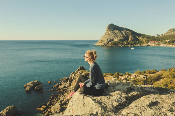 dívka na skalnatém okraji u moře - Fotografie, Obrázek