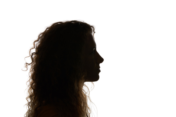 Silueta de mujer rizada mirando hacia otro lado aislada en blanco
 - Foto, Imagen