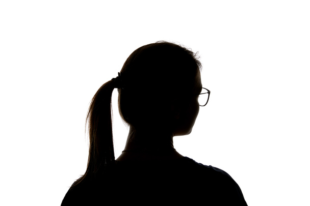 Silhouette de fille dans des lunettes avec queue de cheval regardant loin isolé sur blanc
 - Photo, image