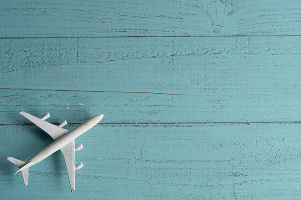 Мініатюрний іграшковий літак на дерев'яному фоні. Подорож літаком
. - Фото, зображення