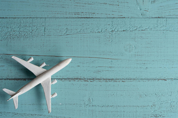 Miniature toy airplane on wooden  background. Trip by airplane. - Foto, afbeelding