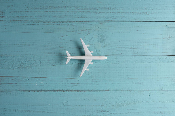 木製の背景にミニチュアおもちゃの飛行機。飛行機での旅. - 写真・画像