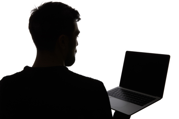 白い上に孤立した空白の画面でノートパソコンを保持している男のシルエット - 写真・画像