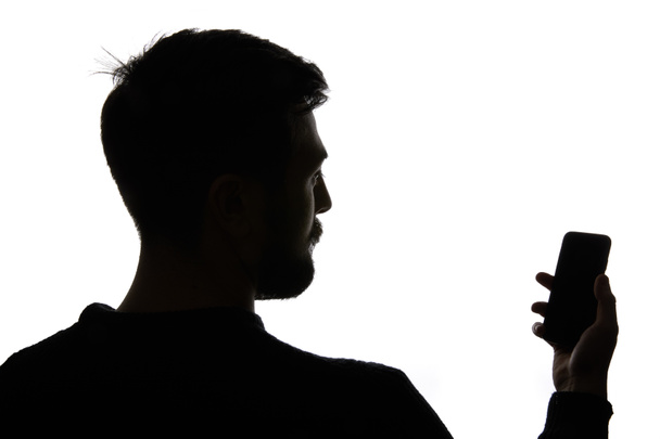 Silueta de hombre sosteniendo teléfono inteligente con pantalla en blanco aislado en blanco
 - Foto, imagen