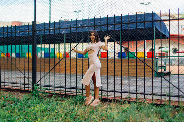 Portrait of a swag girl standing next to the iron fence - 写真・画像