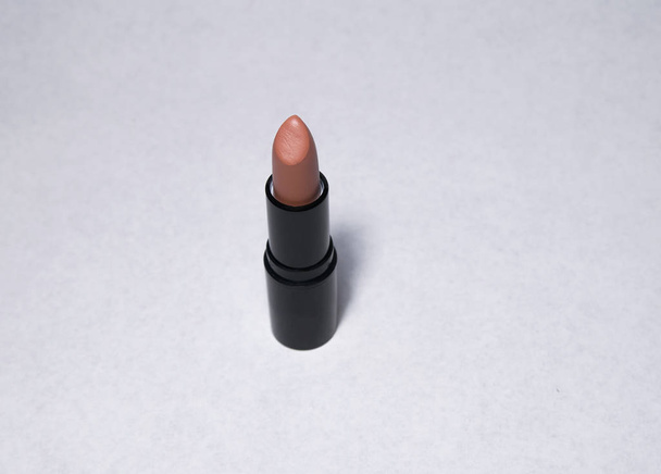 Lipstick of nude color stands upright without a cap on a white background - Fotó, kép
