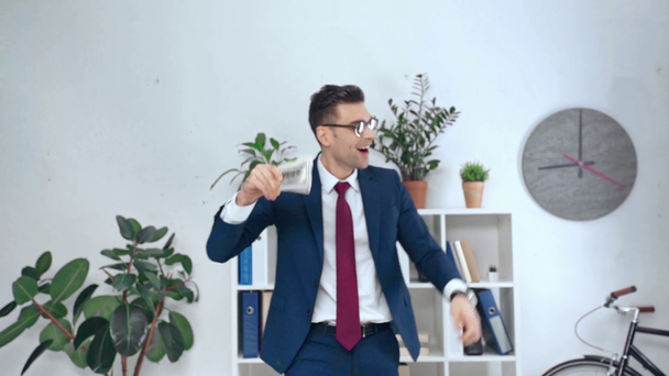 slow motion of excited businessman counting dollar banknotes and showing yes gesture in office - Footage, Video