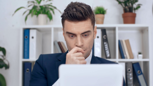selective focus of good-looking, thoughtful businessman using digital tablet in office - Footage, Video