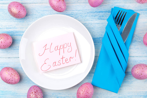 Πάσχα. Ρύθμιση πίνακα Πάσχας. Ροζ Πασχαλινά αυγά σε ένα μπλε ξύλινο τραπέζι. Καλό Πάσχα. διακοπές. θέα από ψηλά. - Φωτογραφία, εικόνα