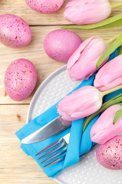Pasqua. Apparecchiare la tavola di Pasqua. Uova di Pasqua rosa e tulipani di fiori su un tavolo di legno naturale. Buona Pasqua. vacanze. vista dall'alto
 - Foto, immagini