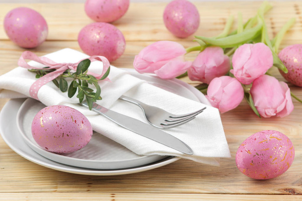 Semana Santa. Mesa de Pascua. Huevos de Pascua rosados y tulipanes de flores en una mesa de madera natural. Feliz Pascua. vacaciones
. - Foto, imagen