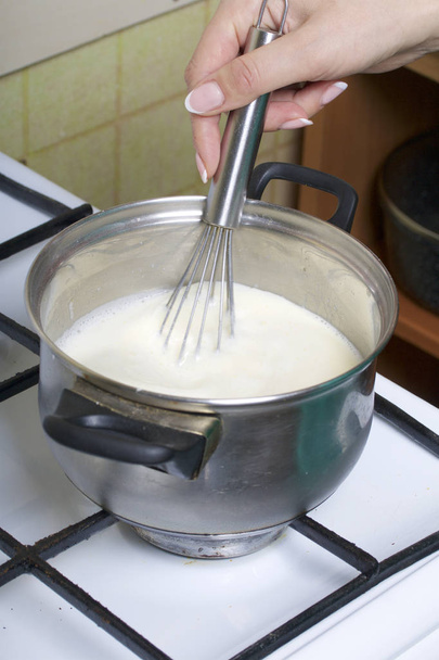 Cooking milk jelly. Cooking a cake of biscuit crumbs and milk jelly. On the surface of the table are the ingredients and cooking utensils. - Φωτογραφία, εικόνα