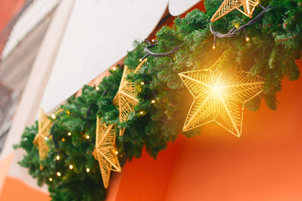 Christmas decorations with golden stars and golden magic light  on orange wall background - Foto, Imagen